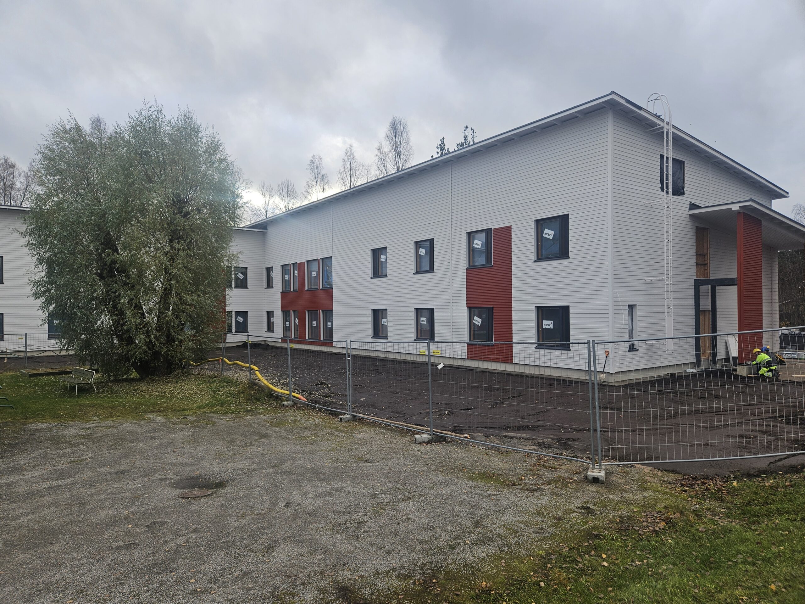 Yksikkö ulkoapäin. Valkoinen rakennus ja ikkunoita