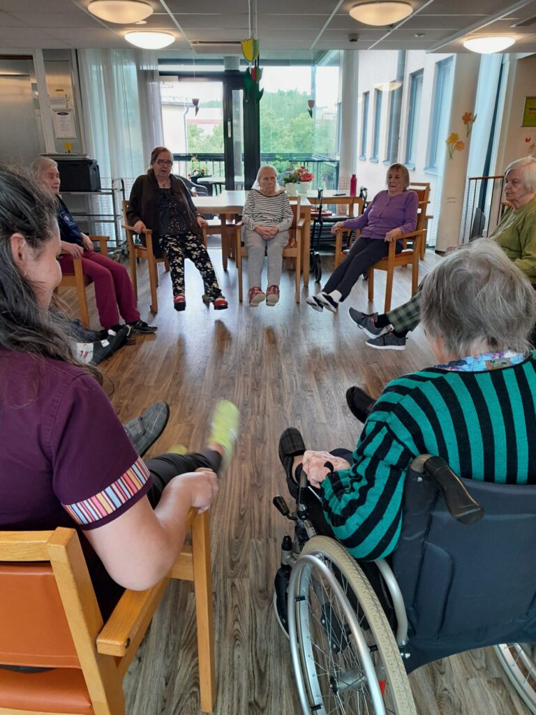 Mainiokoti Tauluhovin asukkailla on mahdollisuus osallistua kolme kertaa viikossa fysioterapeutin ohjaamaan jumppaan.