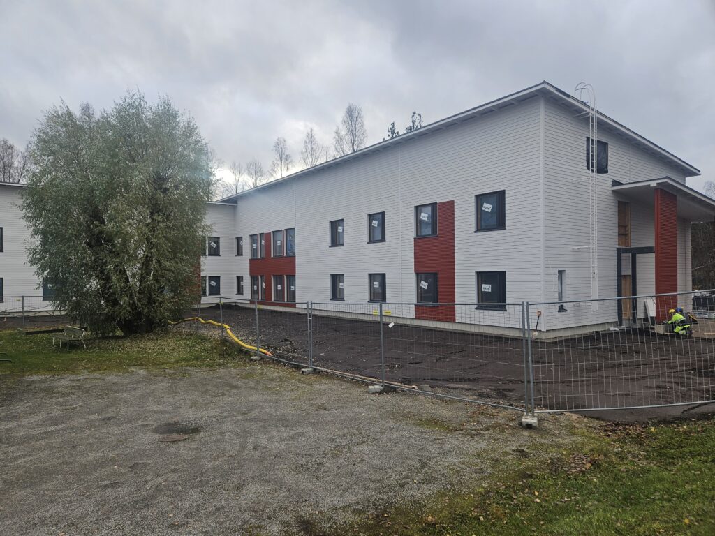 Yksikkö ulkoapäin. Valkoinen rakennus ja ikkunoita