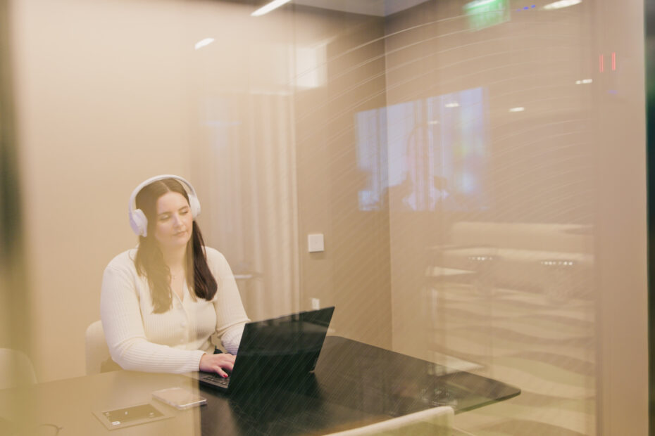 Palvelukoordinaattori tietokoneen äärellä kuulokkeet päässä vastaamassa Mainiokotien palvelunumeron puheluihin