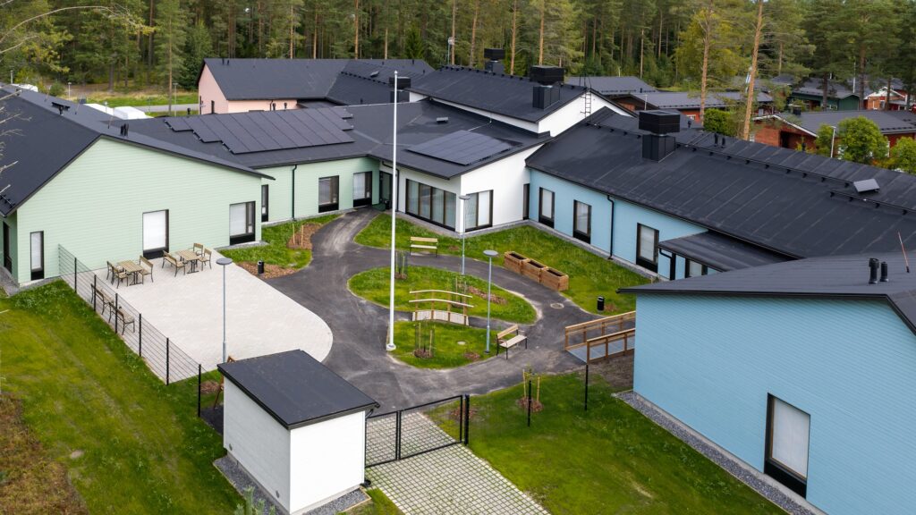 Ilmakuva, jossa rakennus, piha, kävelyreittejä sekä penkkejä.