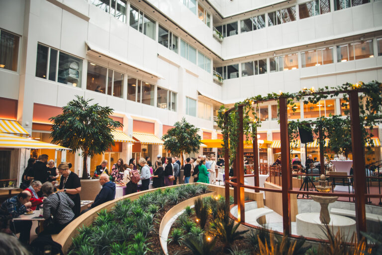Vaalea atrium-piha, jossa viherkasveja ja avajaisvieraita