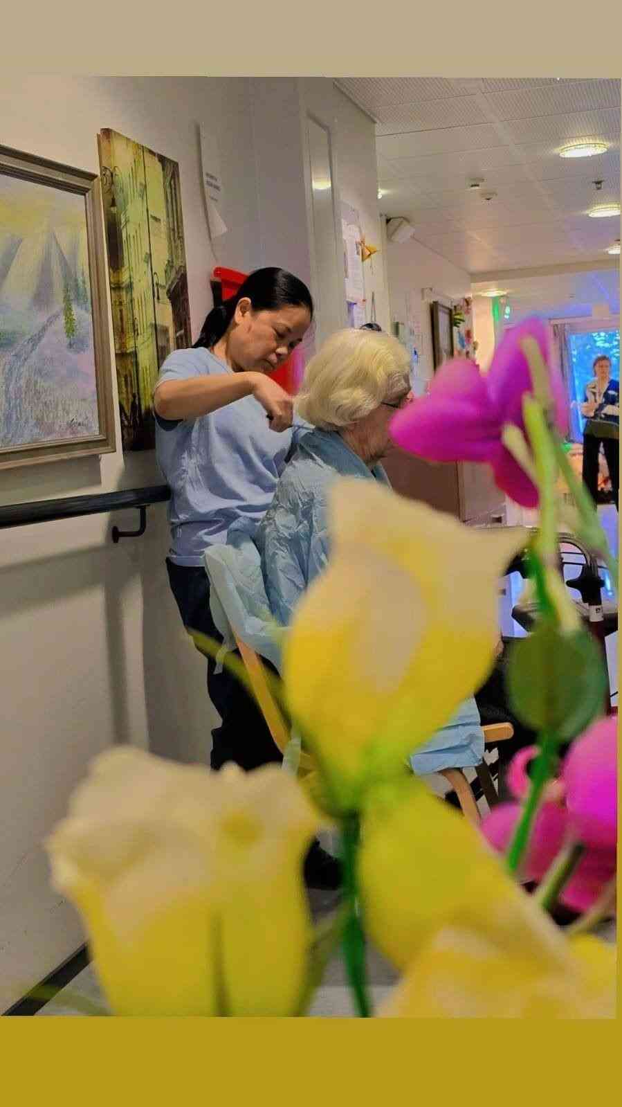 Mainiokoti Käpylän hoitaja kampaa asukkaan hiuksia